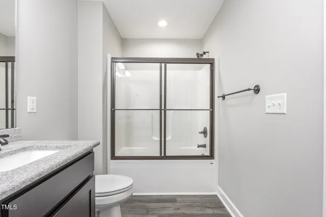 a bathroom with a granite countertop sink toilet and mirror