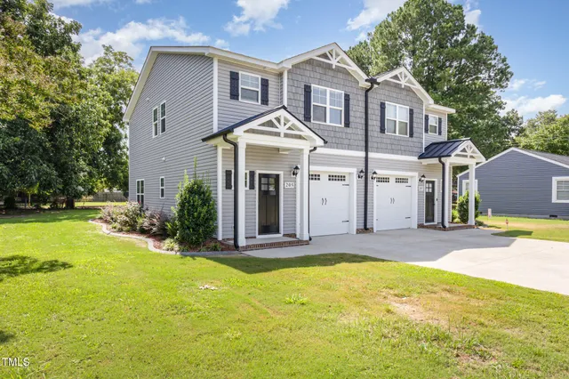 a view of a house with a yard and tree