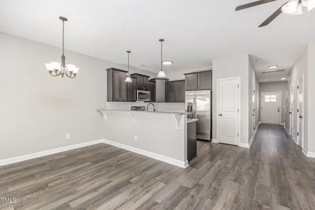 a view of a kitchen with a sink wooden floor and a ceiling fan