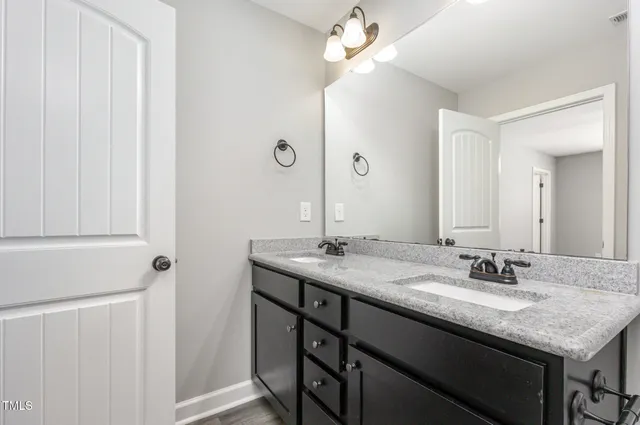a bathroom with a granite countertop sink a mirror and a vanity