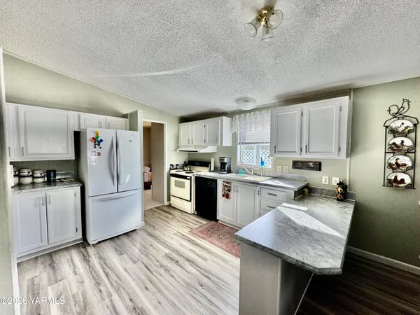 a kitchen with refrigerator and cabinets