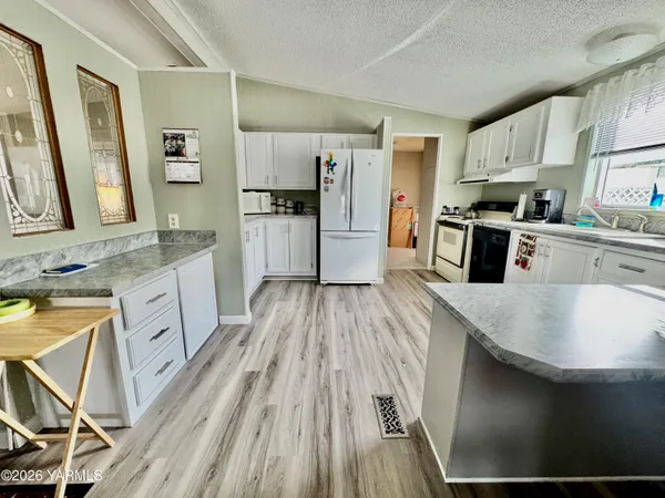 a large kitchen with a lot of counter space and wooden floor
