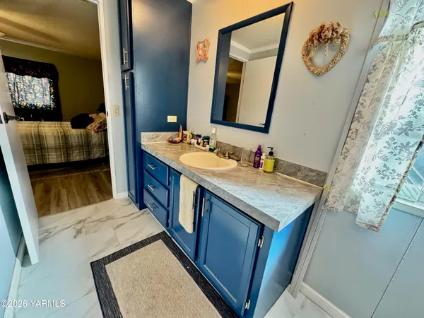 a bathroom with a granite countertop sink vanity mirror and toilet