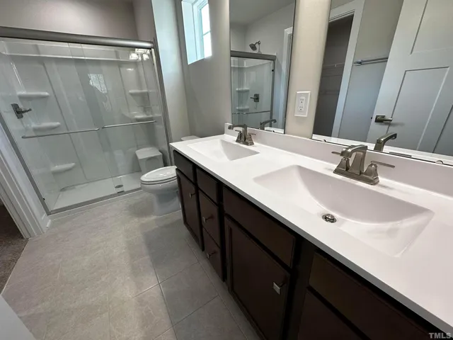 a bathroom with a toilet a sink a light fixture and a mirror