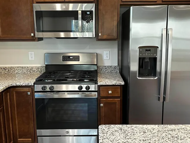 a kitchen with stainless steel appliances wooden cabinets and a stove