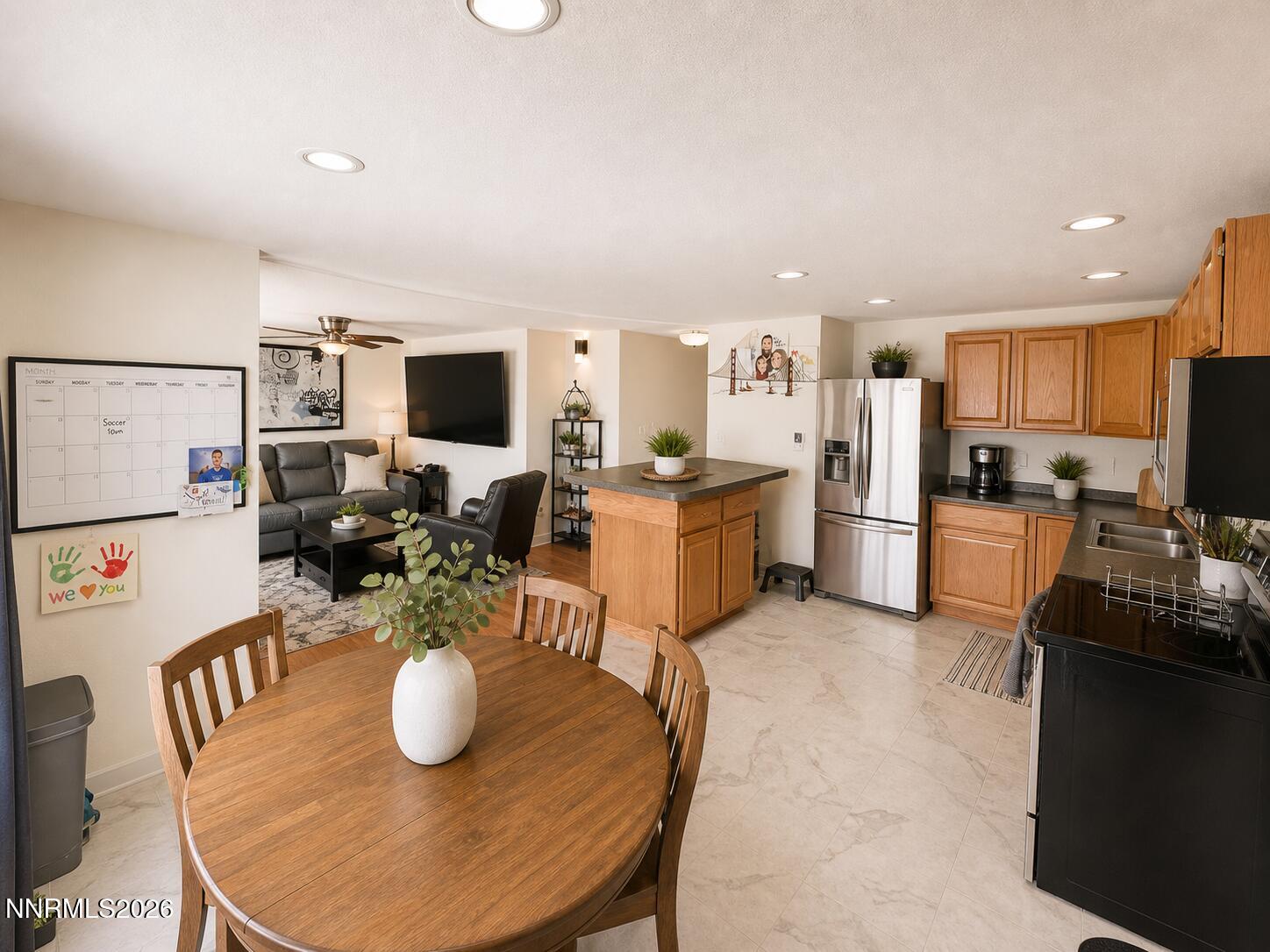 9350 Gremlin Way Reno, NV 89506 - Photo 4 of 7 a kitchen with stainless steel appliances granite countertop a stove refrigerator a dining table and chairs