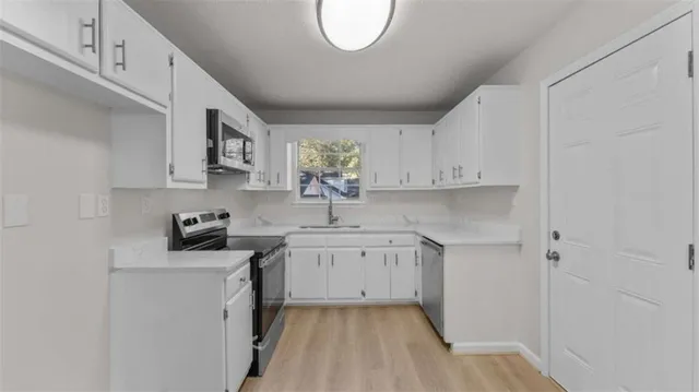 a kitchen with cabinets a sink and appliances