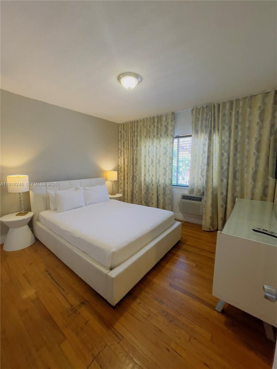 7710 Harding Avenue, Unit 412 Miami Beach, FL 33141 - Photo 6 of 8 a spacious bedroom with a bed and a couch