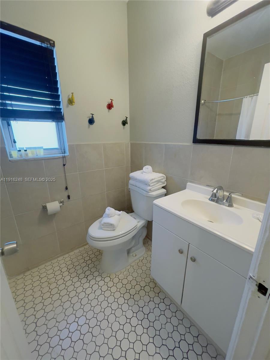 7710 Harding Avenue, Unit 412 Miami Beach, FL 33141 - Photo 8 of 8 a bathroom with a toilet sink and mirror