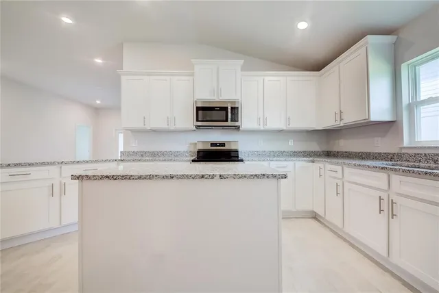 a kitchen with stainless steel appliances granite countertop a sink and cabinets