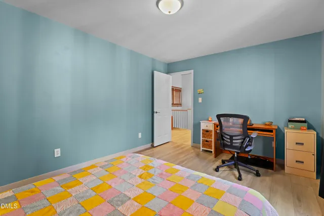 a bed sitting in a bedroom next to a window