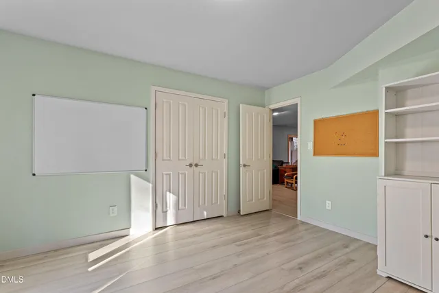 a front view of a house with a yard and large trees