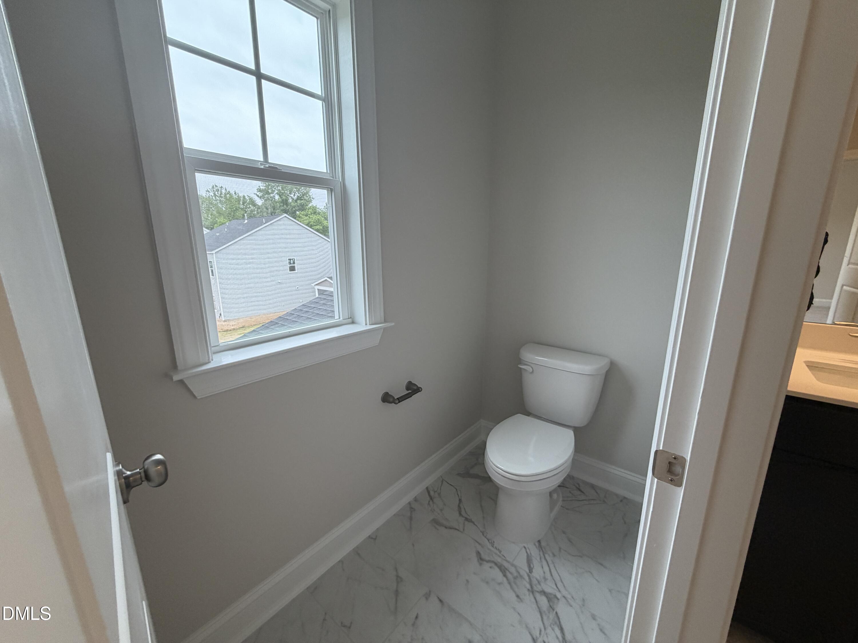 4210 Gray Alder Lane Raleigh, NC 27616 - Photo 17 of 31 a white toilet sitting next to a bathroom sink