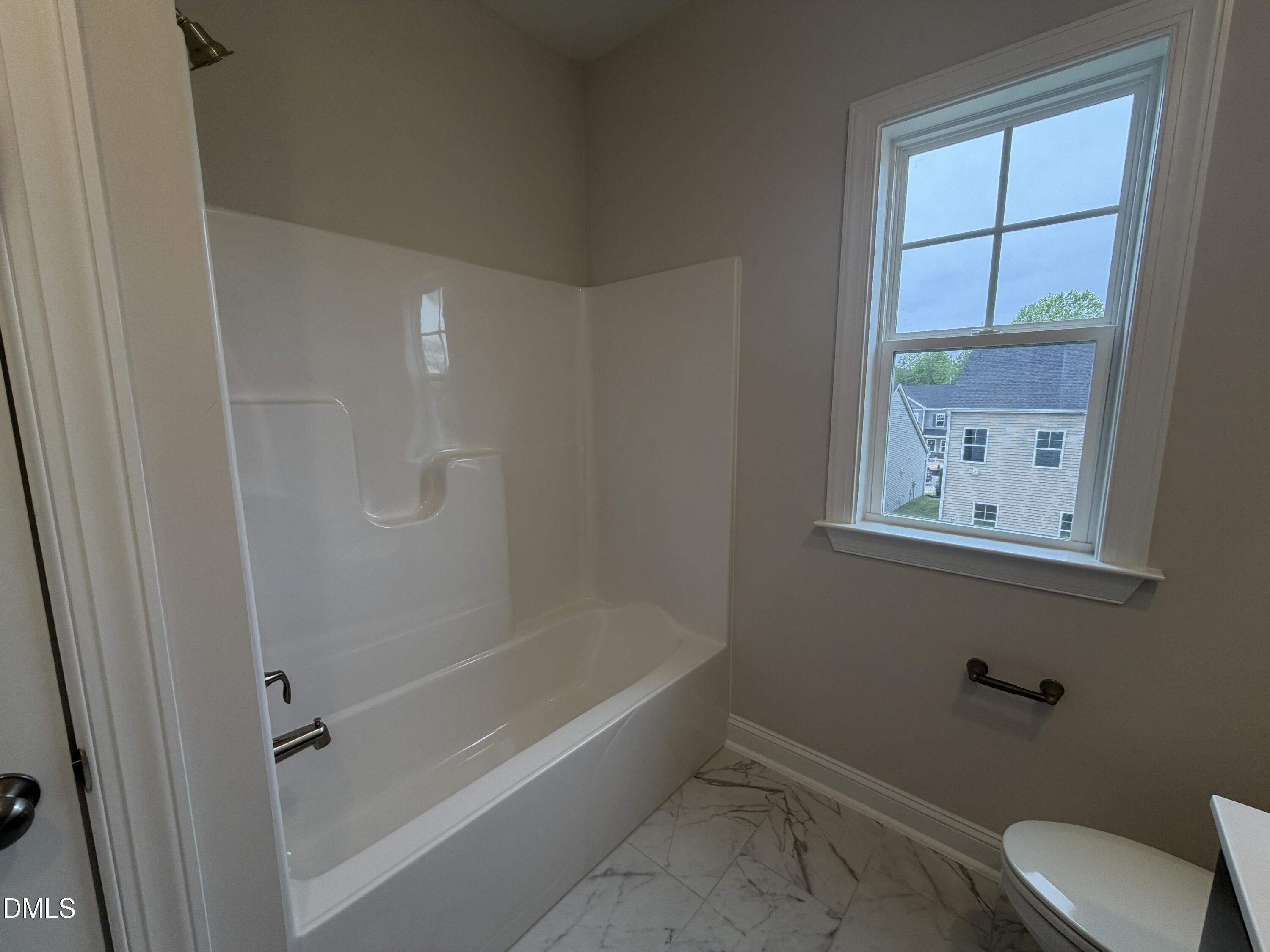 4210 Gray Alder Lane Raleigh, NC 27616 - Photo 22 of 31 a bathroom with a bathtub and window