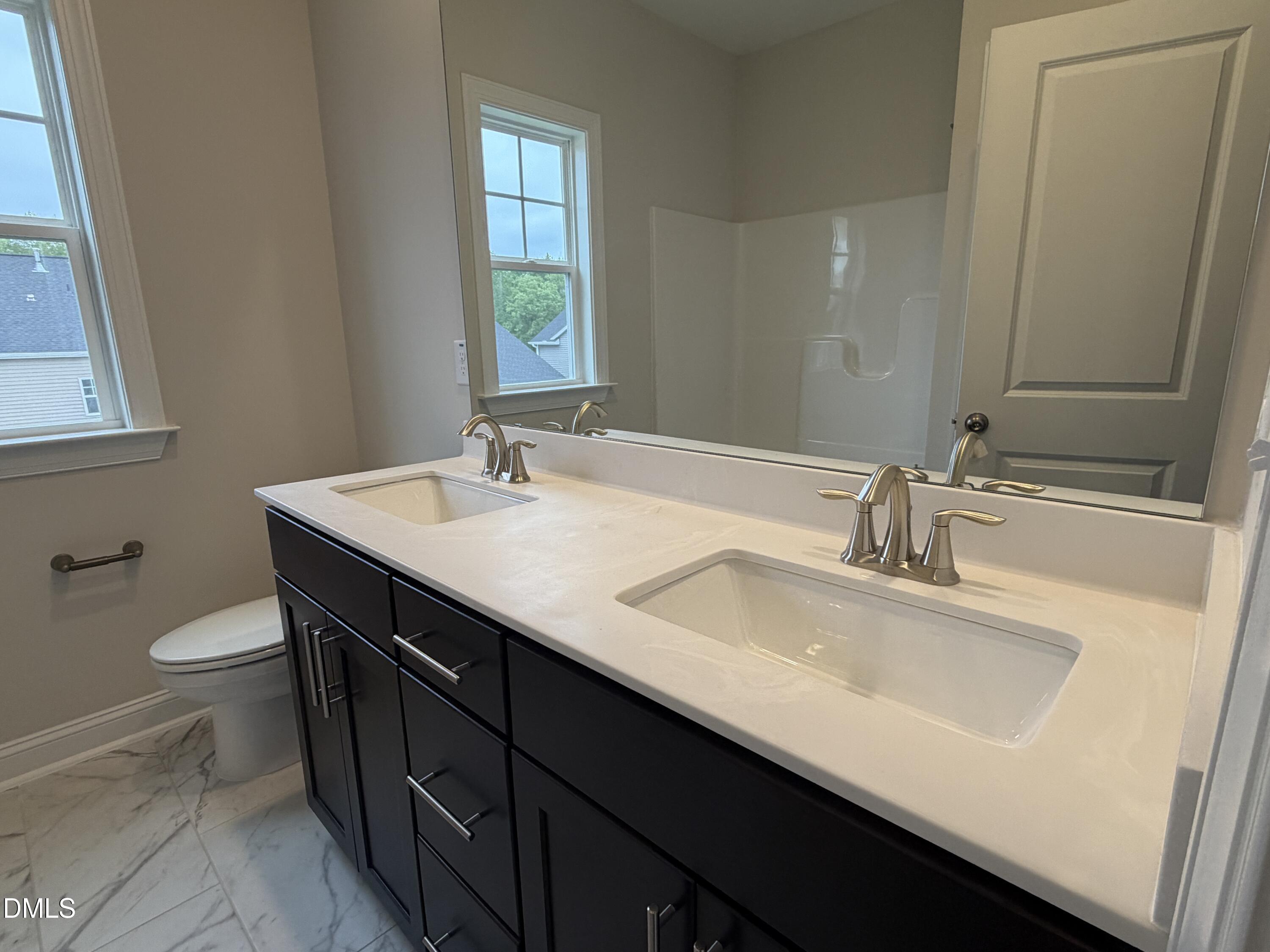 4210 Gray Alder Lane Raleigh, NC 27616 - Photo 23 of 31 a bathroom with a sink double vanity and a toilet