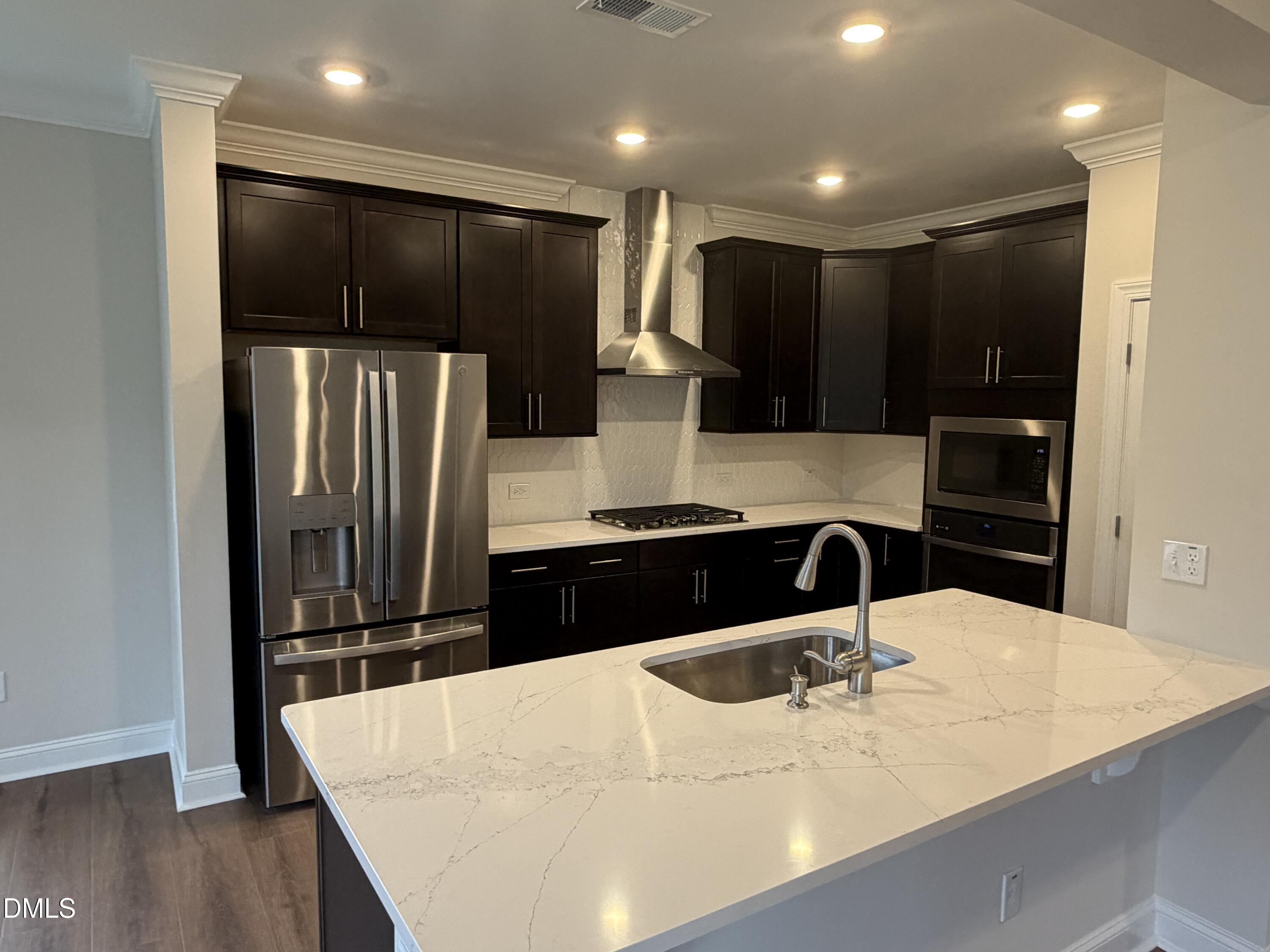 4210 Gray Alder Lane Raleigh, NC 27616 - Photo 4 of 31 a kitchen with stainless steel appliances a refrigerator and a sink