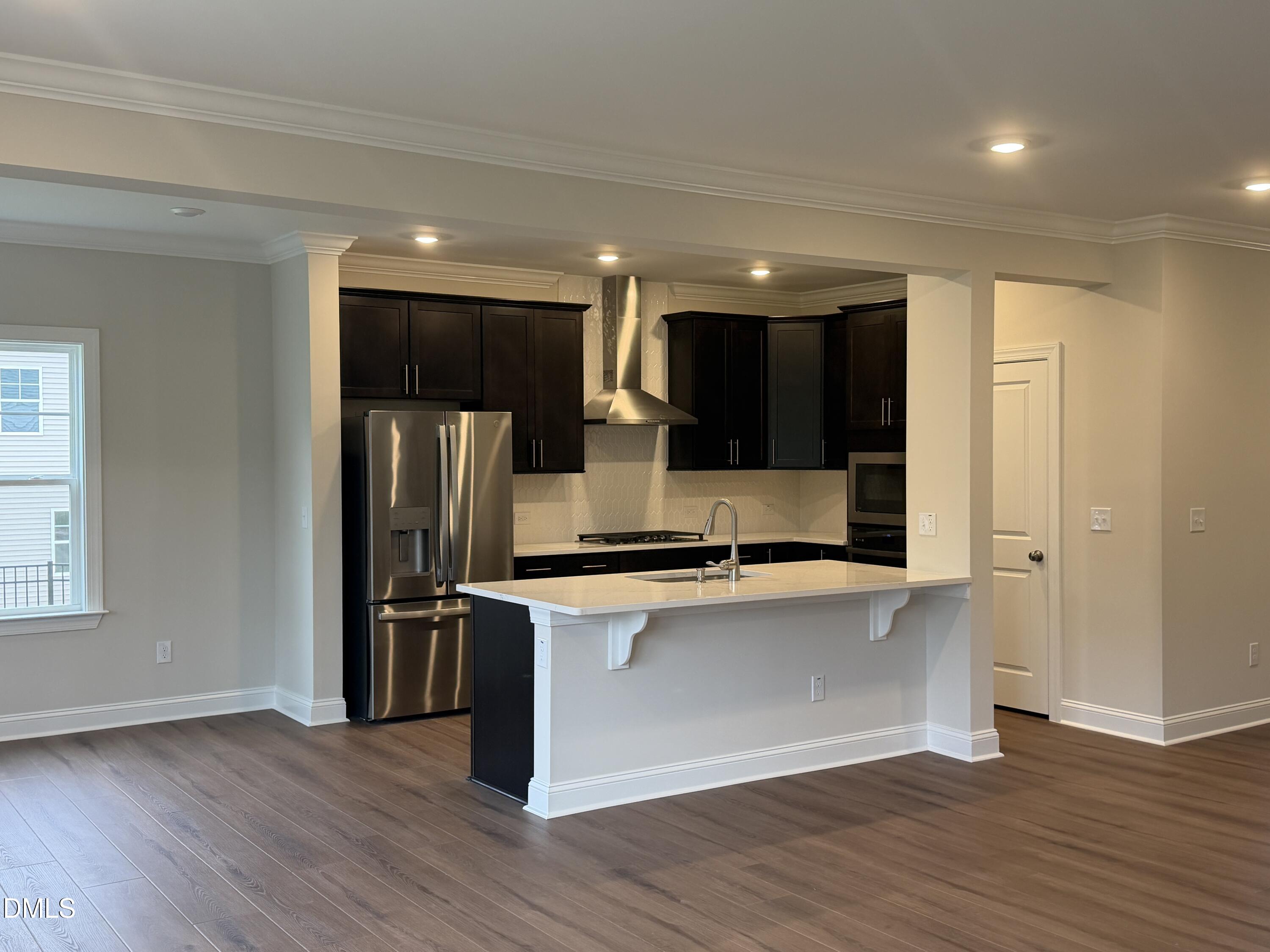 4210 Gray Alder Lane Raleigh, NC 27616 - Photo 9 of 31 an open kitchen with wooden floor and stainless steel appliances