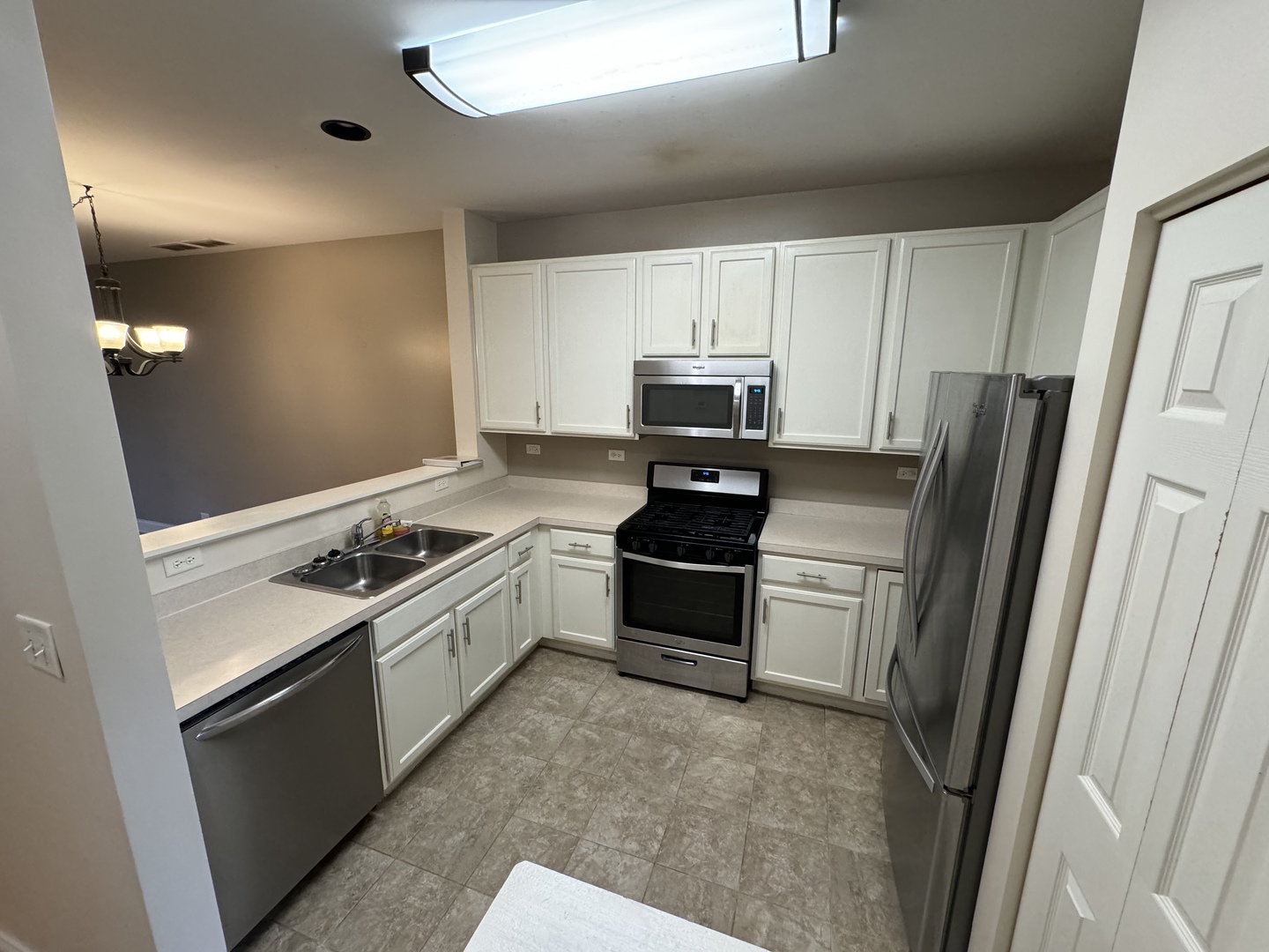 909 Genesee Drive Naperville, IL 60563 - Photo 2 of 26 a kitchen with white cabinets and stainless steel appliances