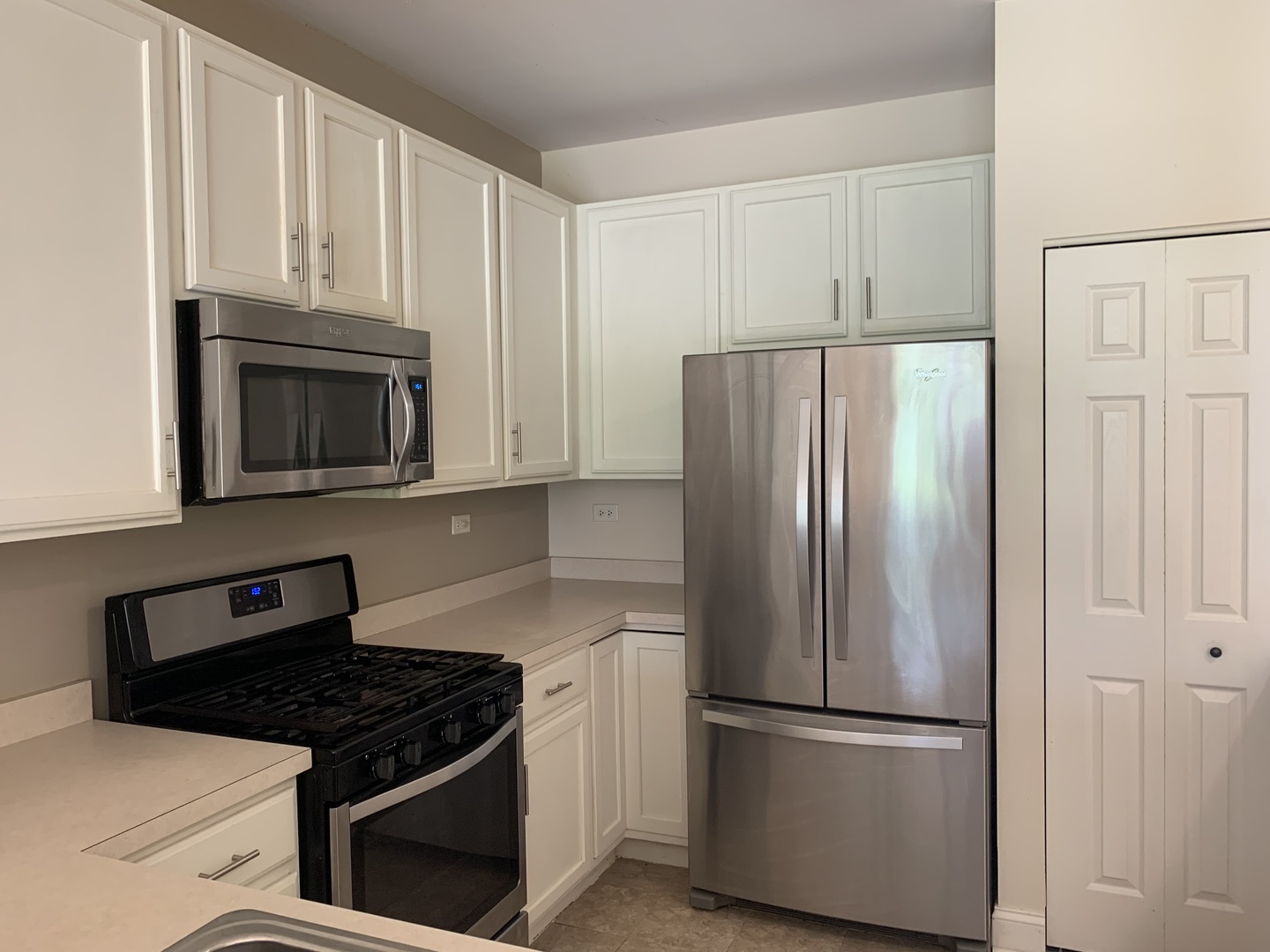909 Genesee Drive Naperville, IL 60563 - Photo 3 of 26 a kitchen with granite countertop white cabinets and stainless steel appliances