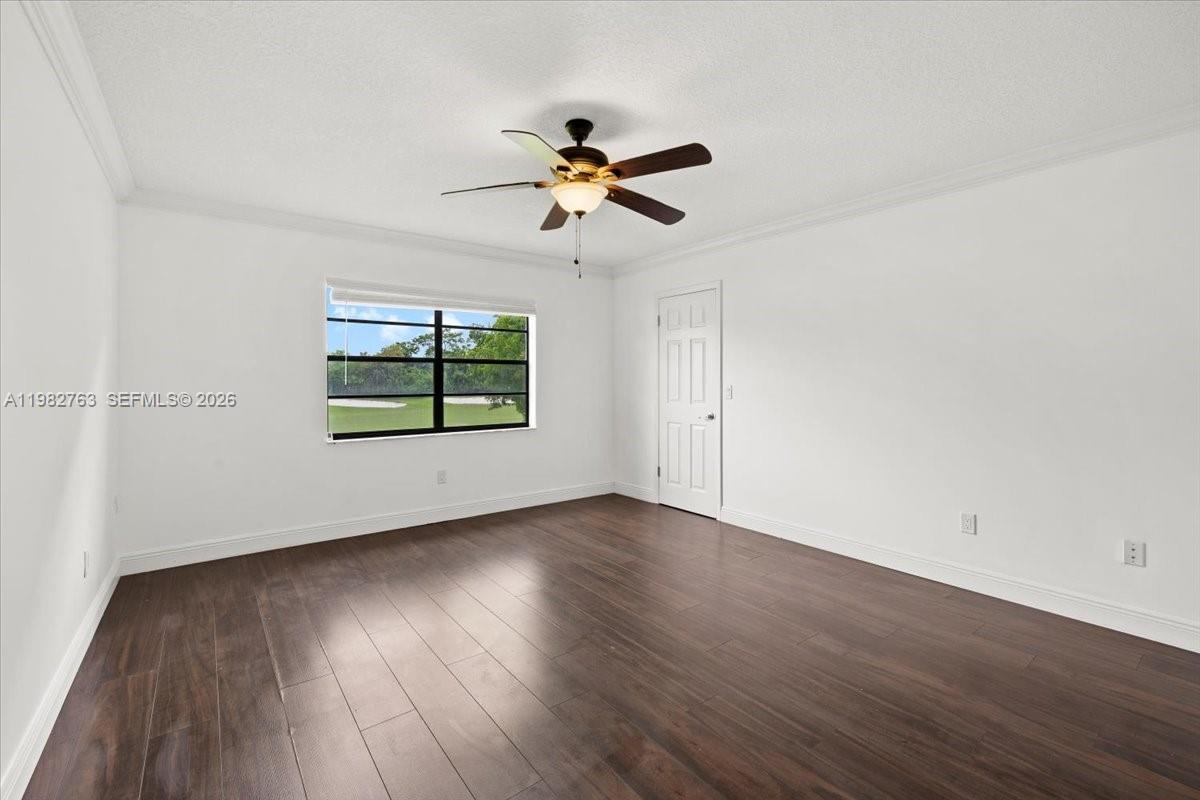 7944 Eastlake Drive, Unit D Boca Raton, FL 33433 - Photo 16 of 29 an empty room with wooden floor ceiling fan and windows