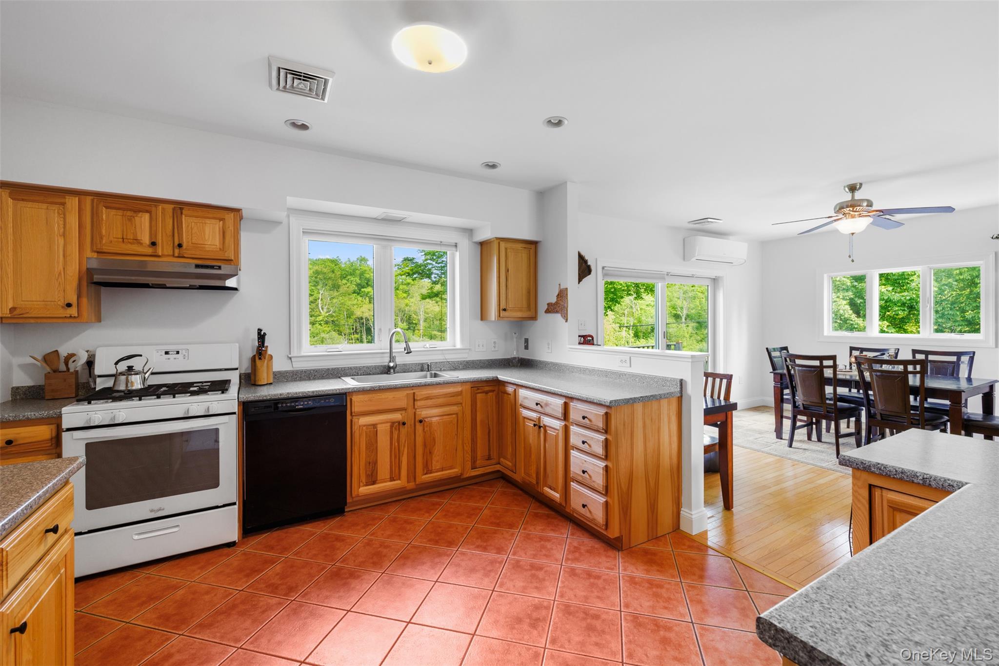 508 Woodstock Road Millbrook, NY 12545 - Photo 13 of 46 a kitchen with stainless steel appliances granite countertop wooden cabinets a sink a stove a dining table and chairs with wooden floor