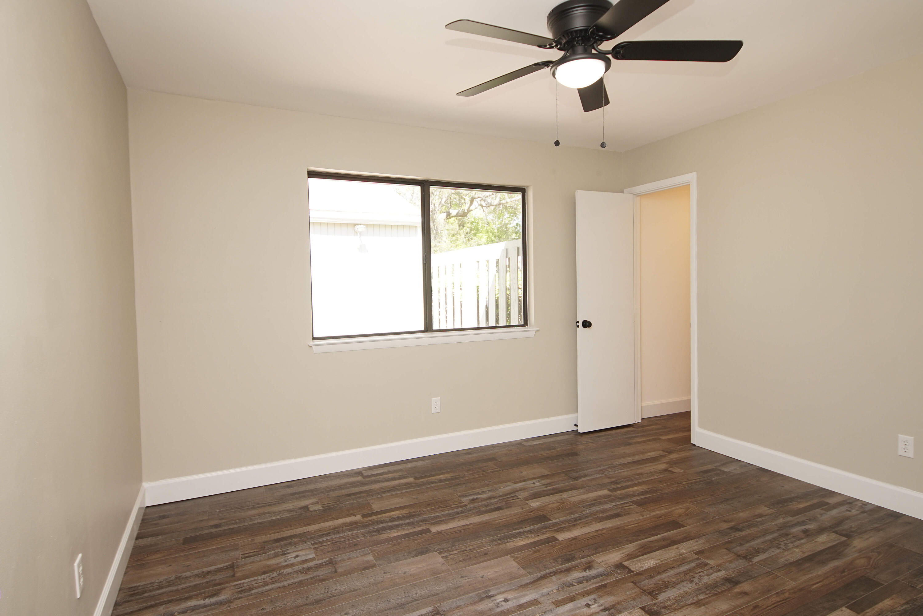800 Bay Drive, Unit 8 Niceville, FL 32578 - Photo 25 of 29 a view of an empty room with window and wooden floor