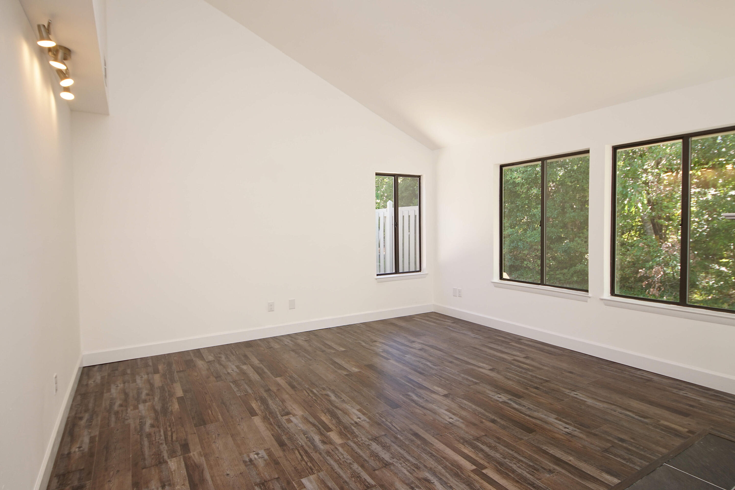 800 Bay Drive, Unit 8 Niceville, FL 32578 - Photo 8 of 29 an empty room with wooden floor and windows