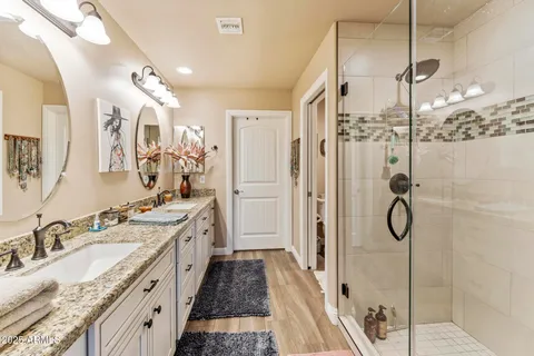 a spacious bathroom with a granite countertop sink mirror and shower