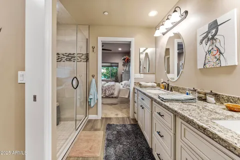 a spacious bathroom with a granite countertop sink mirror and shower