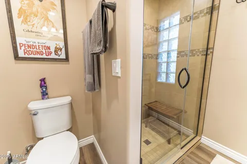 a bathroom with a granite countertop toilet and a shower
