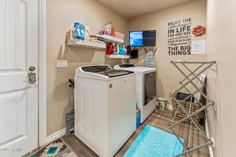 a utility room with dryer washer and a view of living room