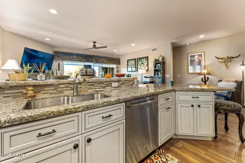 a kitchen with granite countertop a sink and cabinets