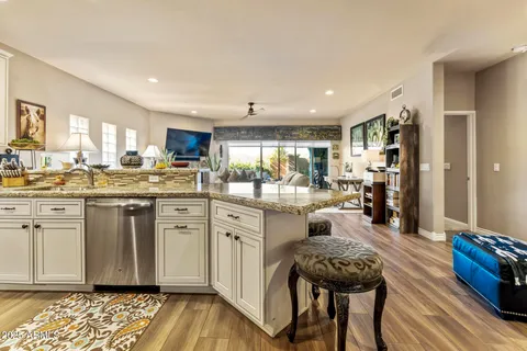 a kitchen with white cabinets and chairs