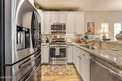 a kitchen with stainless steel appliances a stove sink and microwave