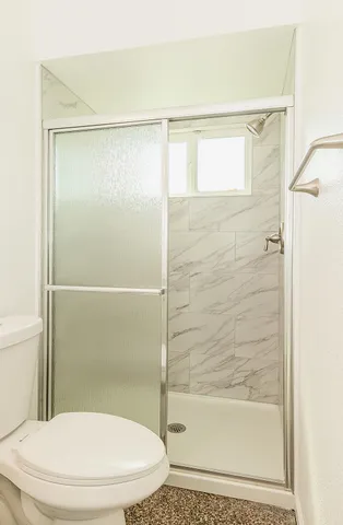 a bathroom with a toilet and a shower