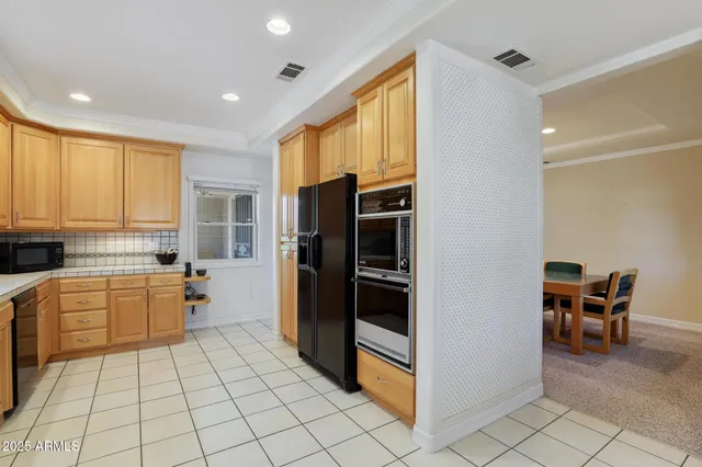 a kitchen with a refrigerator and wooden cabinets