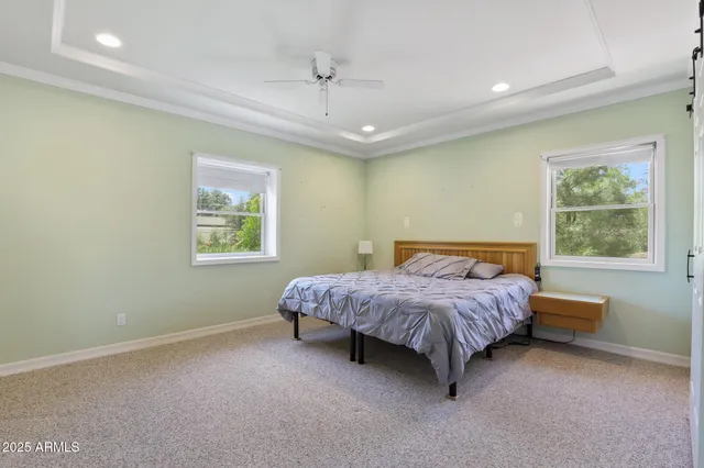 a spacious bedroom with a bed mirror and window