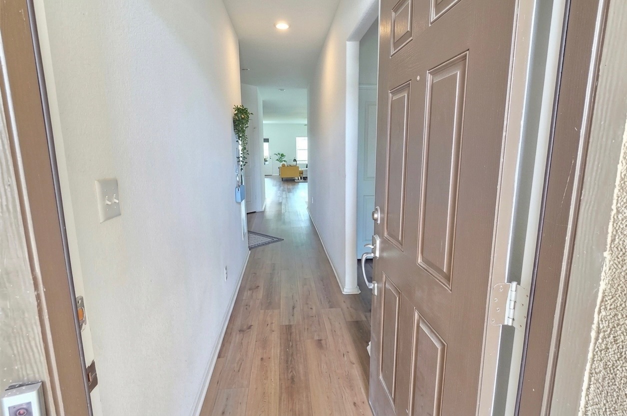 208 Wolf Springs Road Georgetown, TX 78628 - Photo 4 of 32 Step inside to a long, welcoming hallway featuring beautiful wood flooring and recessed lighting.