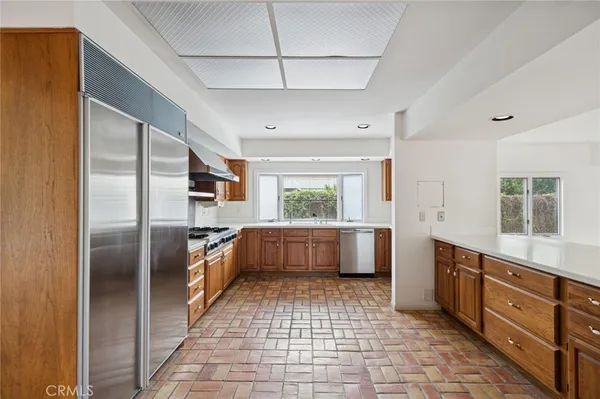 a large kitchen with a large counter top stainless steel appliances and counter space