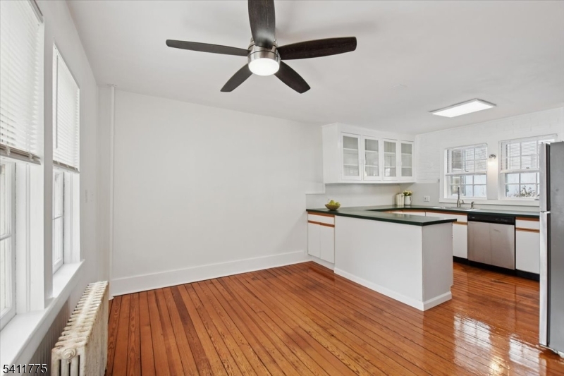 247 Liberty Corner Road Far Hills, NJ 07931 - Photo 4 of 18 a kitchen with granite countertop wooden floors white cabinets and stainless steel appliances