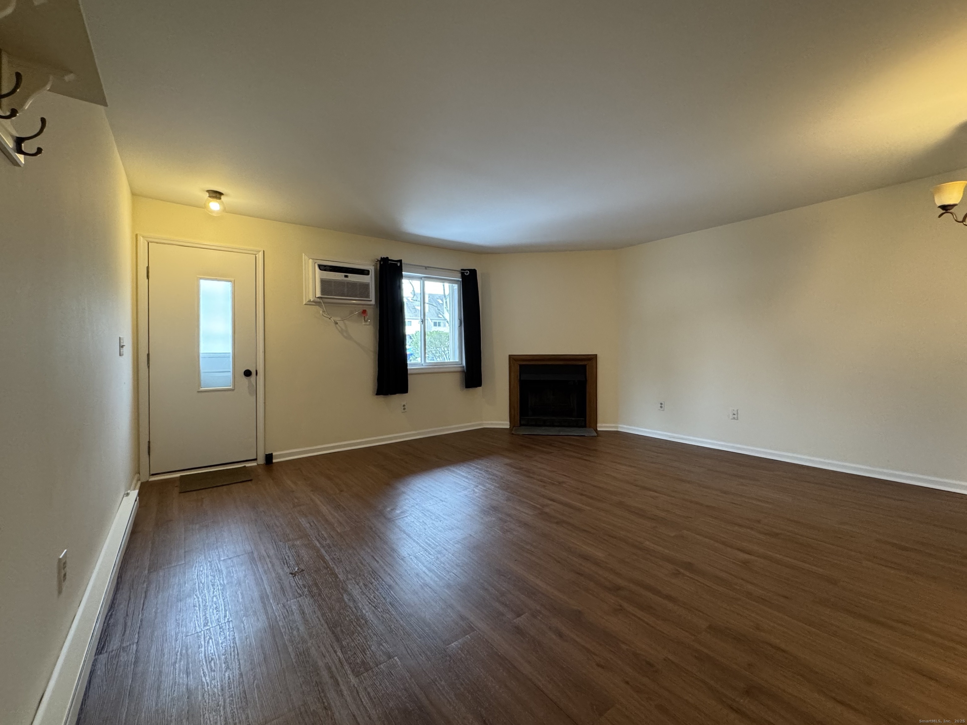 136 Pembroke Road, Unit 11101 Danbury, CT 06811 - Photo 3 of 17 an empty room with wooden floor and mirror