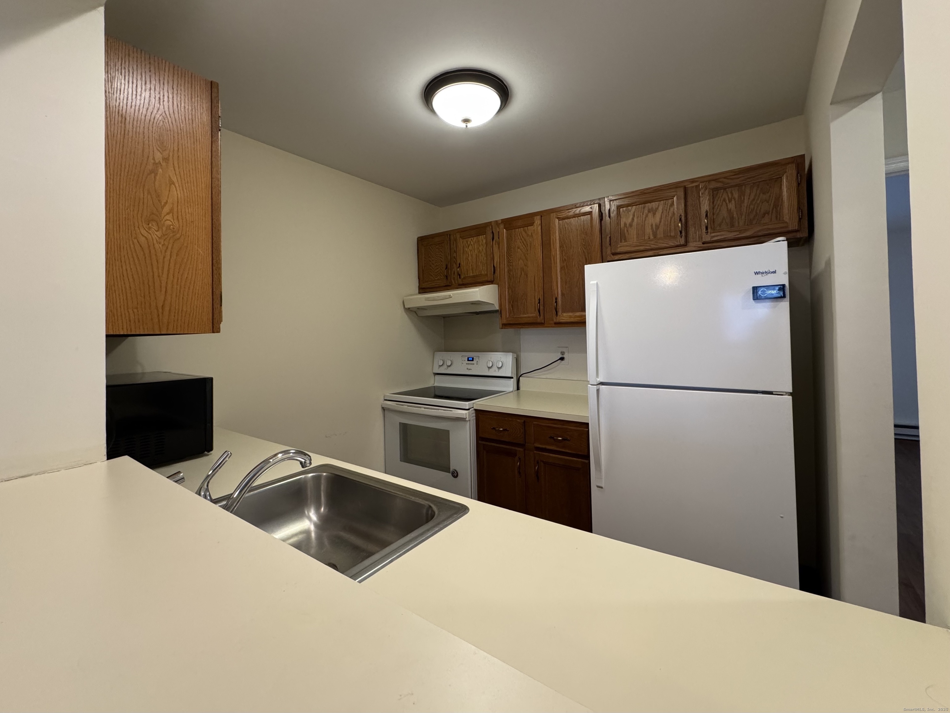 136 Pembroke Road, Unit 11101 Danbury, CT 06811 - Photo 6 of 17 a kitchen with granite countertop a refrigerator and a sink