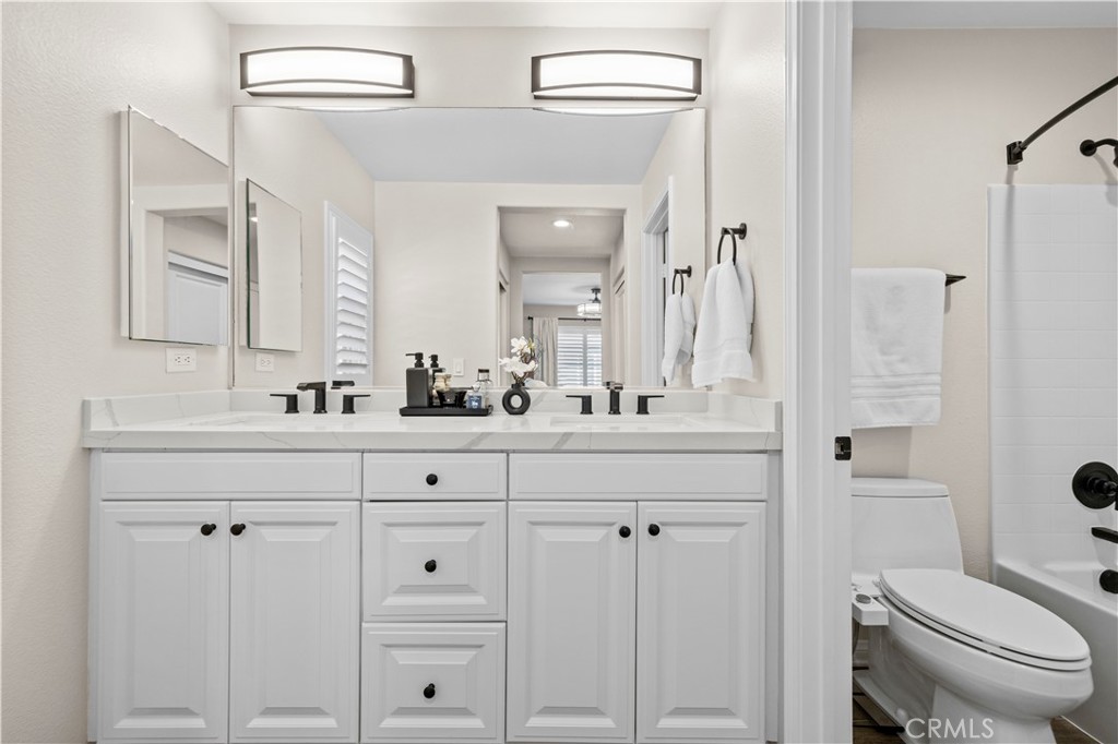 28454 Santa Rosa Lane Saugus, CA 91350 - Photo 24 of 36 a bathroom with double vanity sink a toilet and a mirror