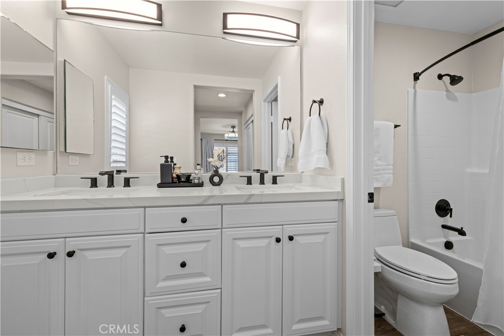 28454 Santa Rosa Lane Saugus, CA 91350 - Photo 25 of 36 a bathroom with a toilet a sink a mirror a vanity and shower