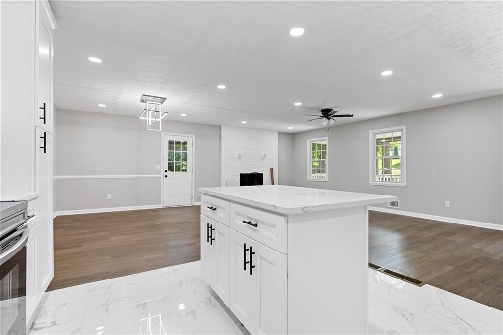 353 Old Rosser Road Stone Mountain, GA 30087 - Photo 13 of 46 a large white kitchen with granite countertop a sink and a stove