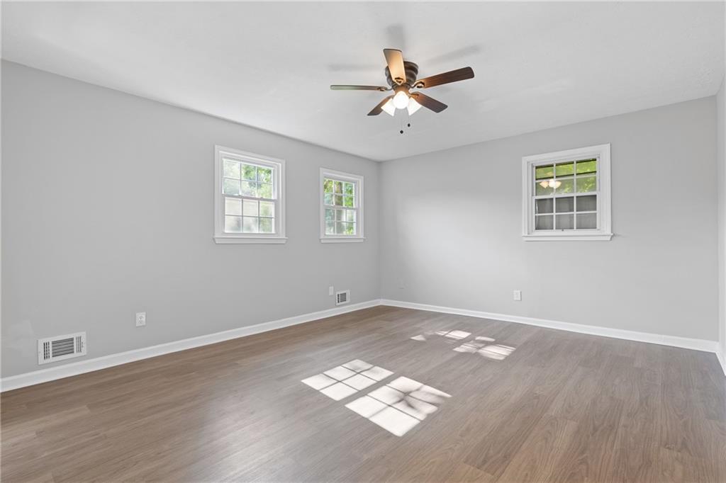 353 Old Rosser Road Stone Mountain, GA 30087 - Photo 20 of 46 a view of an empty room with a window and wooden floor