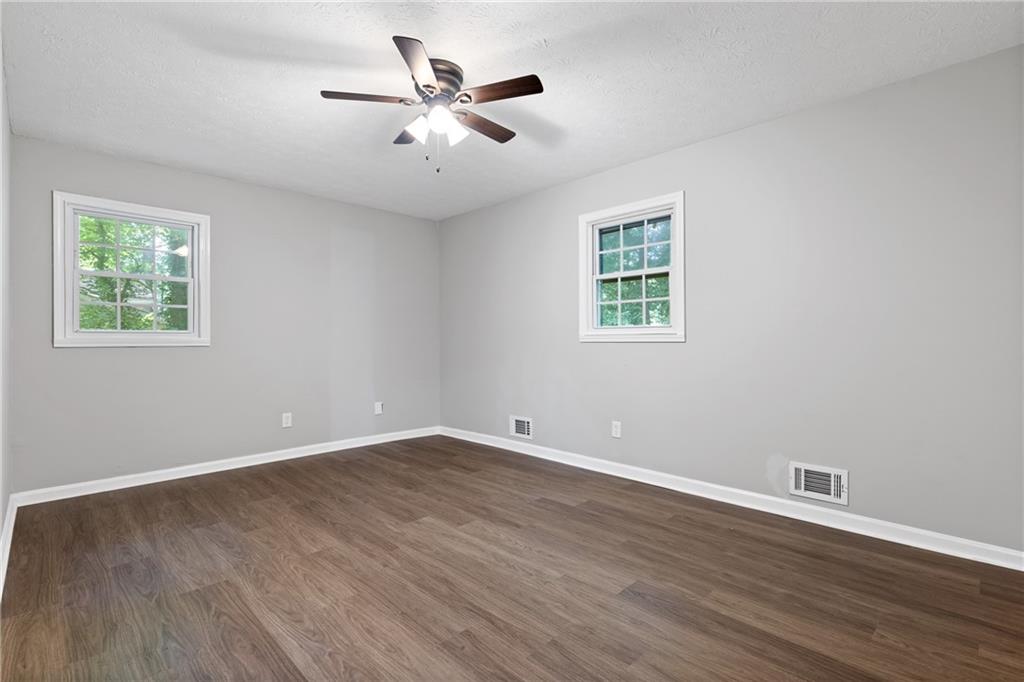 353 Old Rosser Road Stone Mountain, GA 30087 - Photo 22 of 46 a view of an empty room with wooden floor and a window