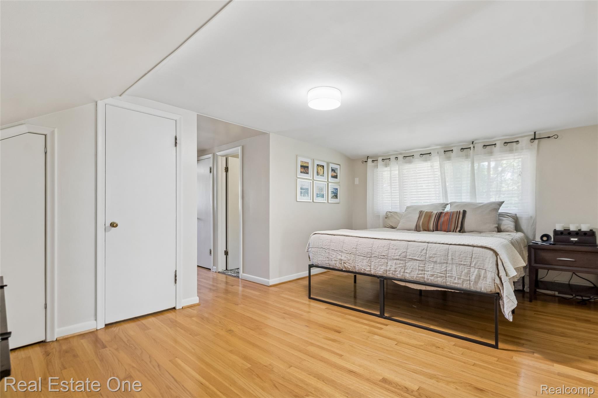 2189 Devonshire Road Bloomfield Hills, MI 48302 - Photo 26 of 50 Hardwood flooring throughout, multiple windows with white blinds, flush mount ceiling light fixture, and white painted doors