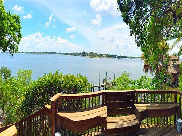 157 South River Road Stuart, FL 34996 - Photo 21 of 23 a view of a wooden chairs and lake from a balcony
