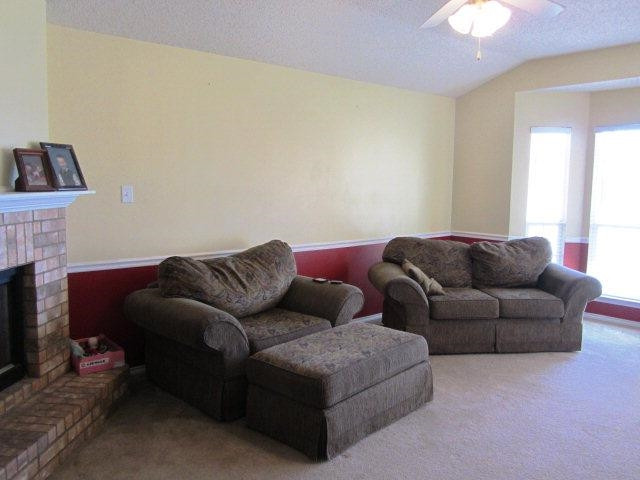 6514 89th Street Lubbock, TX 79424 - Photo 2 of 10 a living room with furniture a fireplace and a chandelier